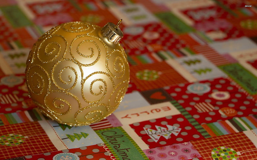 Golden bauble on Christmas wrapping paper HD wallpaper