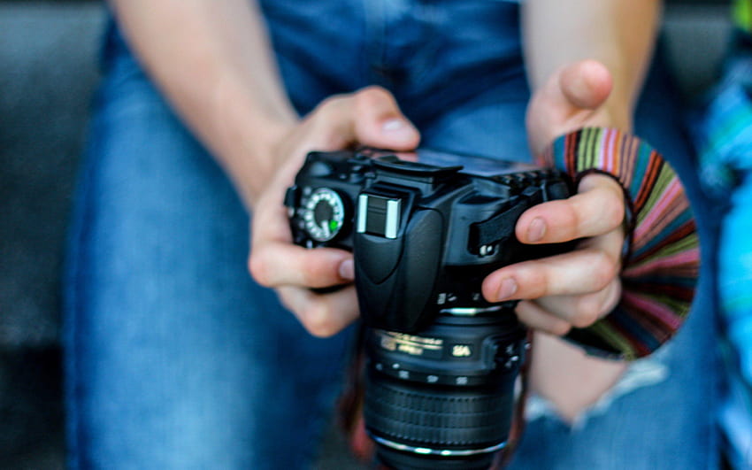 un fotógrafo sosteniendo una cámara en la mano hola fondo de pantalla