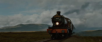 Download The Iconic Hogwarts Express Train Riding Along a Scenic Route  Wallpaper | Wallpapers.com