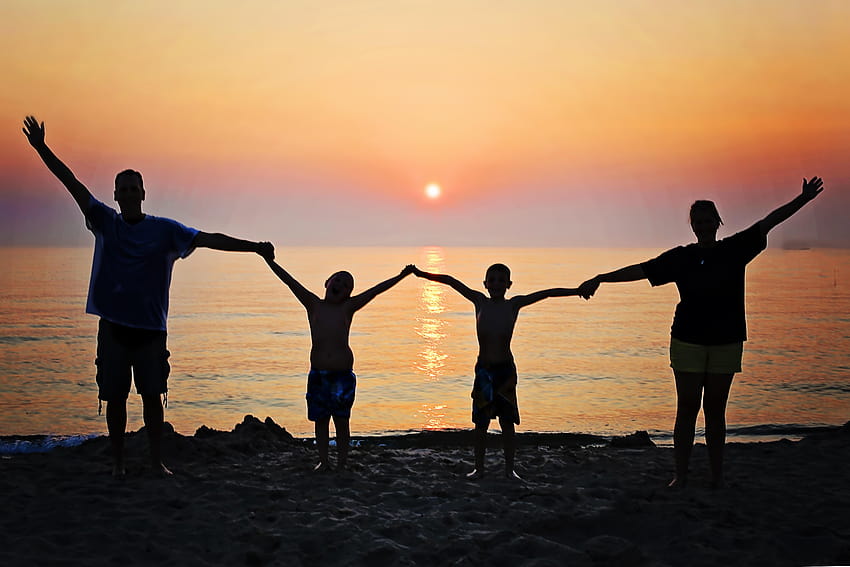Silueta de hombre, mujer con sus dos hijos sosteniendo mientras, puesta de sol familiar fondo de pantalla