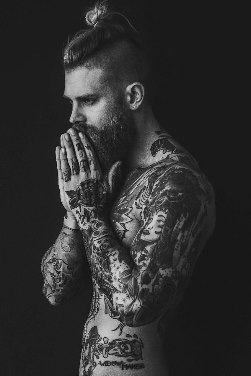 Tattooed man in trendy clothes Man with tattoo on strong arm skin Fashion  macho with confidence and charisma Tattoo model with beard on unshaven  face Fashion style and trend vintage filter 
