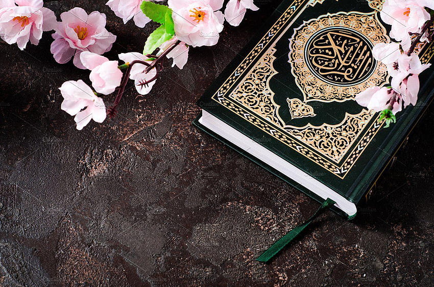 Islamska Księga Koran i wiosenne kwiaty brunch na ciemnym tle z koranem w tle Tapeta HD