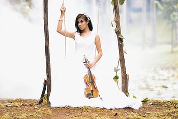 Brunette girl wearing a white dress with a Louis Vuitton b…