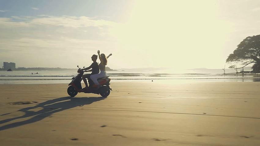 Pasangan mengendarai sepeda motor di pantai dekat air matahari terbit dengan gerakan lambat Stok Rekaman Video, pasangan pengendara sepeda Wallpaper HD