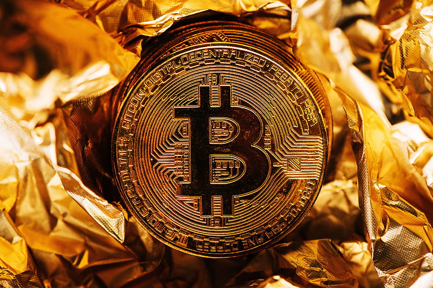 Bitcoin Goldmünze auf Folie und HD-Hintergrundbild
