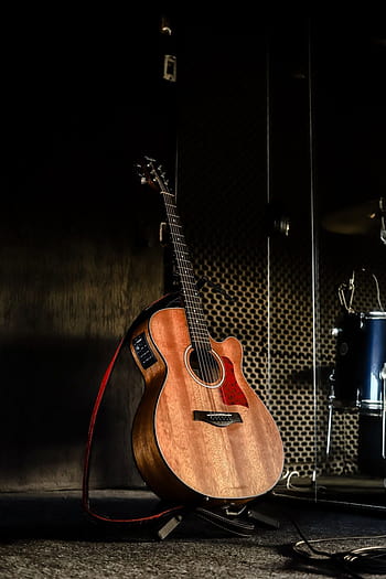 Black Acoustic Guitar Leaning on the White Wall · Free Stock Photo