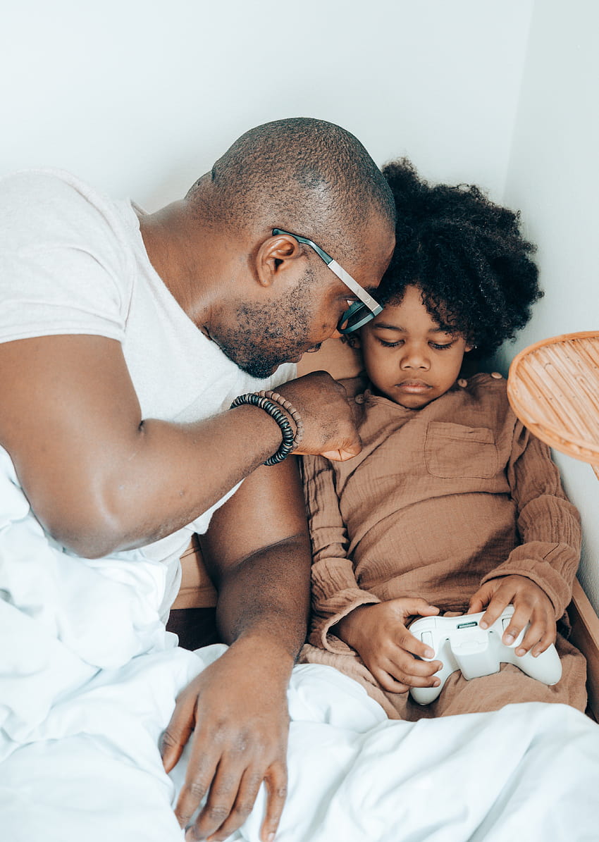 Kochający czarny ojciec spędza czas z uroczą córką w łóżku w domu · Stock, ojcostwo Tapeta na telefon HD