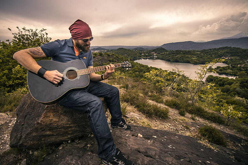 Man Playing Guitar Sitting on Brown Rock · Stock, guitar player HD wallpaper