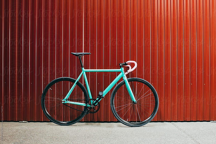 Минималистичен тюркоазен велосипед с фиксирана предавка, облегнат на блестяща червена метална стена от VISUALSPECTRUM, минималистичен фиксиран HD тапет
