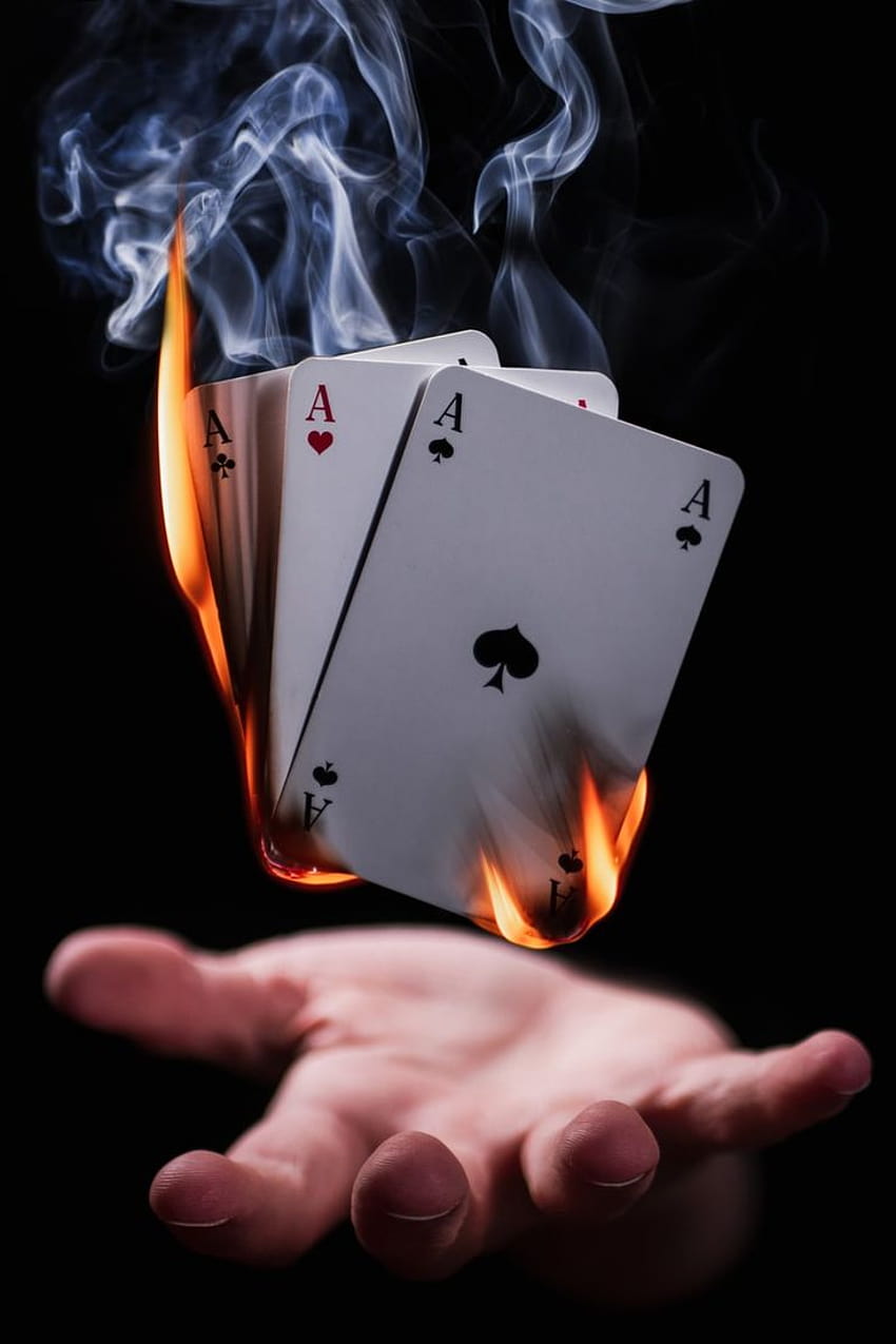 Hand below levitating burning cards, gamble phone HD phone wallpaper