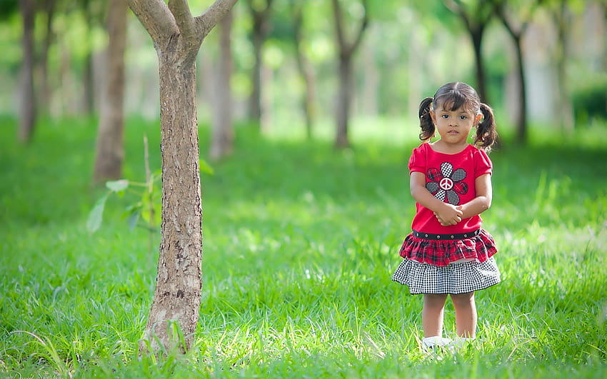 Schönes süßes kleines Mädchen, das still im Garten steht, schönes Kind HD-Hintergrundbild