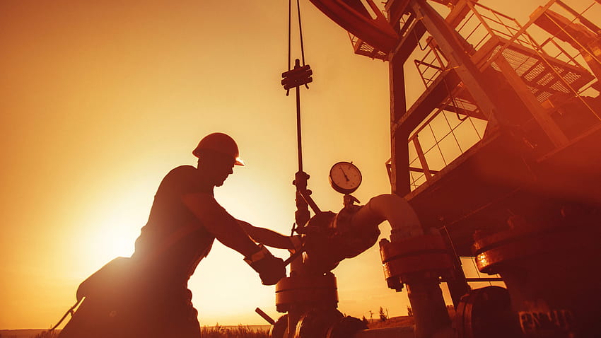 El trabajador petrolero está revisando la bomba de aceite en el de la puesta del sol., trabajador del campo petrolero fondo de pantalla